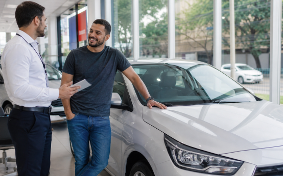 Motorista de aplicativo conversando sobre financiamento de carro novo em concessionária